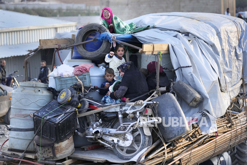 Pengungsi Suriah duduk di belakang truk di samping barang-barang mereka, saat mereka menunggu di titik berkumpul untuk menyeberangi perbatasan pulang ke Suriah, di kota perbatasan Lebanon timur Arsal, Lebanon, Rabu, 26 Oktober 2022.