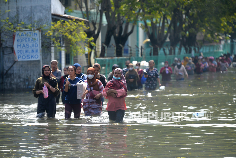 Pekerja pelabuhan menerobos banjir rob di dalam Pelabuhan Tanjung Emas, Semarang, Jawa Tengah, Jumat (27/5/2022). (Ilustrasi)