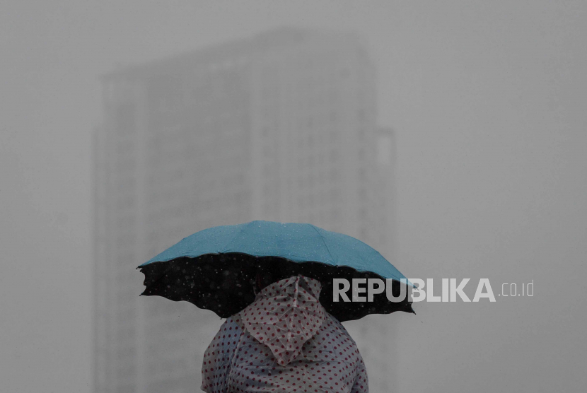 Warga berjalan menggunakan payung di kawasan Kemayoran, Jakarta. Ilustrasi.