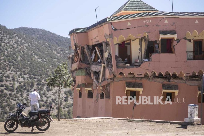 Seorang pria berdiri di samping hotel yang rusak pasca gempa di desa Moulay Brahim, dekat pusat gempa, di luar Marrakesh, Maroko, Sabtu, (9/9/2023).