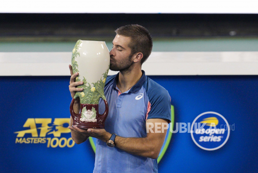 Borna Coric, dari Kroasia, mencium Piala Rookwood setelah mengalahkan Stefanos Tsitsipas, dari Yunani, pada final tunggal putra turnamen tenis Western & Southern Open, Ahad, 21 Agustus 2022, di Mason, Ohio.
