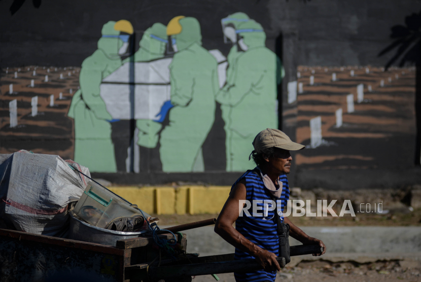 Warga tidak menggunakan masker dengan benar saat berjalan melintasi mural bertema Covid-19 di kawasan Bukit Duri, Tebet, Jakarta Selatan, Selasa (8/9). Jumlah kasus positif Covid-19 di Tanah Air pada Selasa (8/9) bertambah sebanyak 3.046 kasus baru dan secara akumulasi kasus Covid-19 di Indonesia menembus angka 200.035 orang. Republika/Thoudy Badai