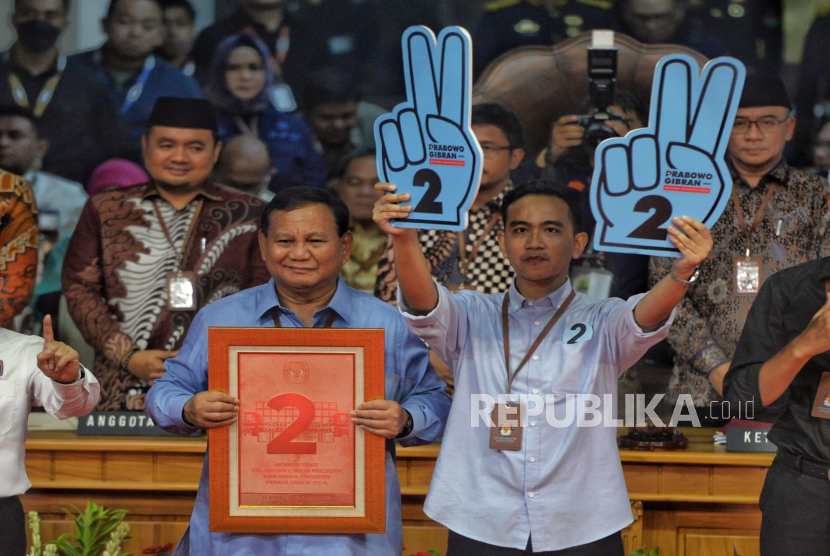 Pasangan capres Prabowo Subianto dan cawapres Gibran Rakabuming Raka memegang plakat nomer urut 2 usai pengundian di kantor KPU, Jakarta Pusat, Selasa (14/11/2023).