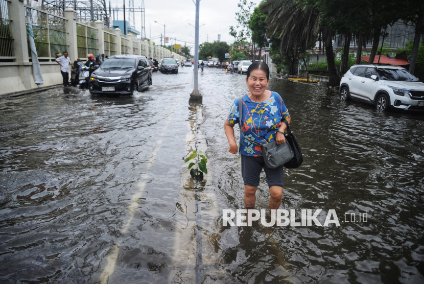 Warga melintasi banjir rob di Kawasan Pluit Karang Ayu Barat, Jakarta, Senin (16/12/2024). Banjir luapan air laut atau rob tersebut menggenangi salah satu akses jalan untuk memasuki kawasan pelabuhan Muara Angke. Banjir rob dikawasan tersebut mencapai ketinggian sekitar 10 hingga 60 sentimeter (cm) yang berakibat aktivitas warga di sekitar menjadi terhambat. Menurut informasi sudah empat hari banjir rob merendam beberapa tempat di wilayah Jakarta Utara. Sebelumnya Badan Meteorologi Klimatologi dan Geofisika telah mengeluarkan peringatan dini banjir rob pada pada tanggal 11 Desember - 20 Desember 2024.