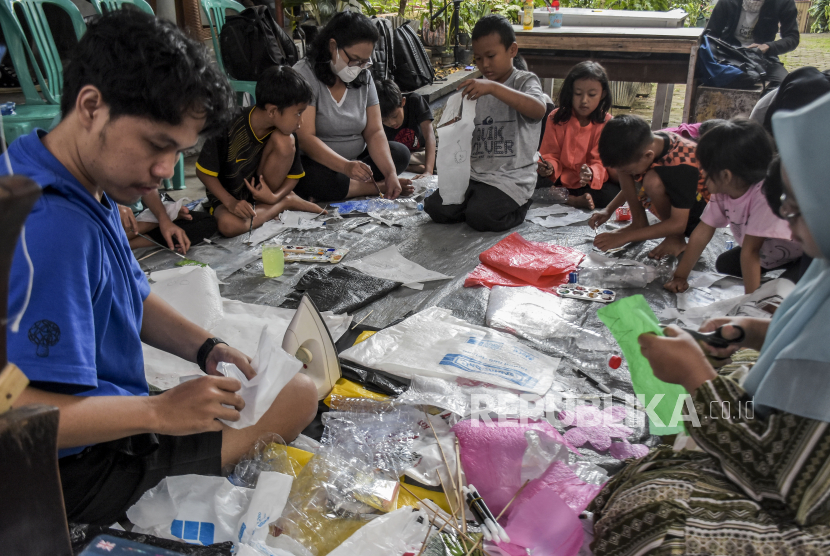 Sejumlah anak didampingi orang tua membuat wayang dari bahan sampah plastik saat lokakarya pembuatan wayang plastik di Jalan Terusan Cibogo Atas, Sukajadi, Kota Bandung, Ahad (18/9/2022). Lokakarya yang diinisiasi oleh Wayang Plastik (WATIK) dan Sedekah Benih tersebut sebagai upaya kampanye menjaga dan memperbaiki lingkungan dengan bijak mengolah sampah plastik. Republika/Abdan Syakura