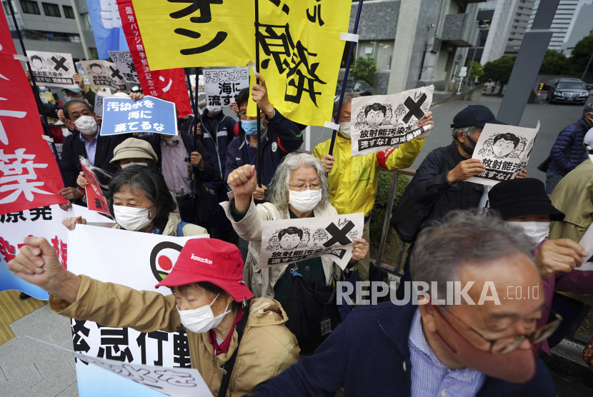 Orang-orang meneriakkan slogan-slogan menentang keputusan pemerintah untuk mulai melepaskan sejumlah besar air radioaktif yang diolah dari pembangkit nuklir Fukushima yang rusak ke laut, selama unjuk rasa di luar kantor perdana menteri di Tokyo pada Selasa, 13 April 2021. 