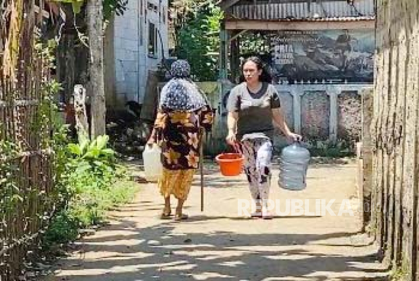 Warga Kampung Pabuaran, Desa Ciampea, Kecamatan Ciampea, Kabupaten Bogor mengantre mengambil air bersih yang didistribusikan Pemerintah Desa Ciampea, Selasa (12/9/2023).