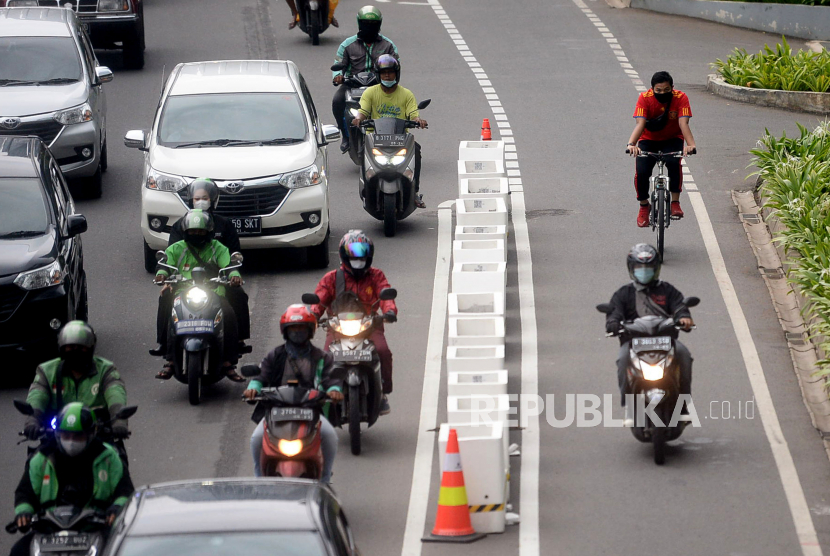 Pengedara sepeda motor melintas di jalur sepeda permanen di kawasan Sudirman, Jakarta, Jumat (5/3). 