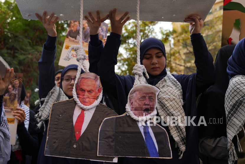 Para pendukung Hizbullah memegang tiang gantungan tiruan Perdana Menteri Israel Benjamin Netanyahu, kiri, dan mantan Presiden AS Donald Trump, kanan 