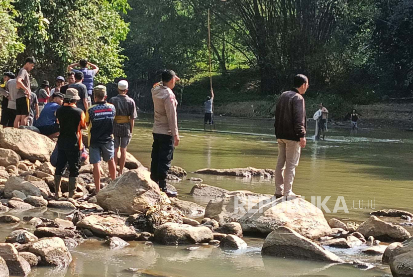 Polisi bersama warga di lokasi tenggelamnya seorang anak di aliran Sungai Ciwulan, Desa Cintajaya, Kecamatan Tanjungjaya, Kabupaten Tasikmalaya, Jawa Barat, Rabu (9/8/2023). 