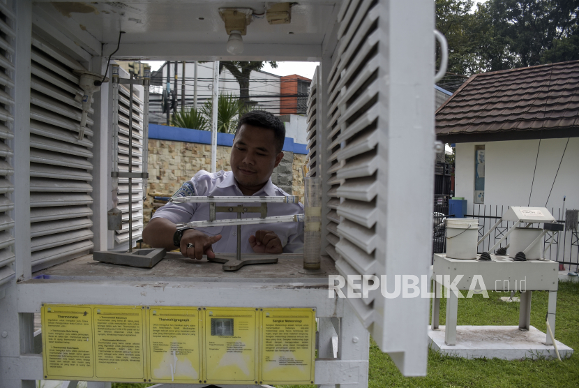 Petugas mengukur suhu dan kelembapan udara menggunakan termometer di dalam sangkar meteorologi di halaman kantor BMKG Stasiun Geofisika Kelas I Bandung, Jawa Barat, Senin (18/12/2023). 