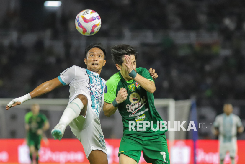 Pesepak bola PSBS Biak Muhammad Tahir (kiri) berebut bola dengan pesepak bola Persebaya Surabaya Francisco Rivera (kanan) pada pertandingan BRI Liga 1 di Stadion Gelora Bung Tomo, Surabaya, Jawa Timur, Sabtu (15/2/2025). Persebaya Surabaya mengalahkan PSBS Biak dengan skor 1-0. Gol kemenangan Persebaya dicetak Bruno Moreira Soares di menit ke-54.