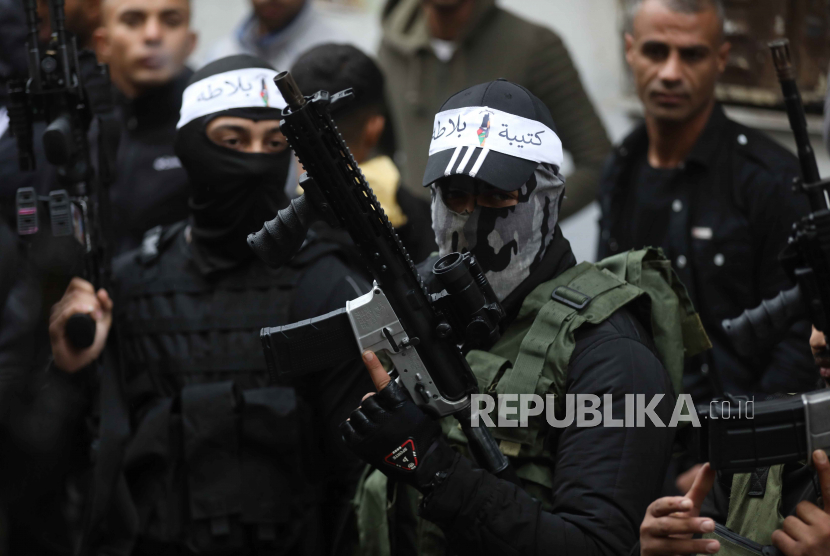  Otoritas Israel Keluarkan Larangan Bepergian kepada Pria Ini. Foto:   Militan memegang senjata mereka selama pemakaman Mahdi Hashash Palestina, 17, di kamp pengungsi Balata dekat kota tepi barat Nablus, 09 November 2022. Seorang remaja Palestina Rabu pagi 09 November ditembak mati oleh tembakan Israel selama serangan militer Israel ke area Makam Joseph, di sebelah timur kota Nablus, Tepi Barat yang diduduki, kata Kementerian Kesehatan Palestina.