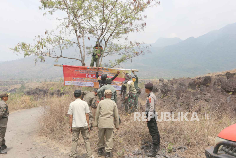 Petugas gabungan melakukan pemasangan spanduk larangan aktivitas penambangan ilegal di kawasan Gunung Guntur, Kabupaten Garut, Jawa Barat, Jumat (10/11/2023). 