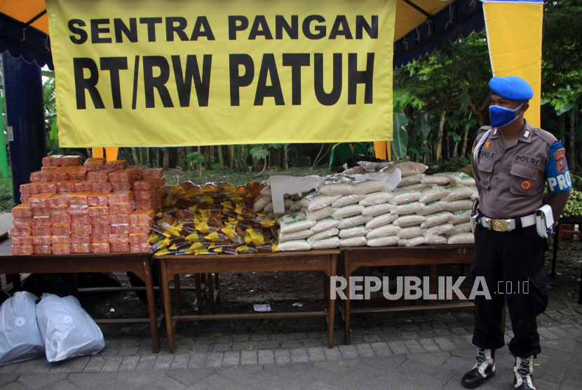 Petugas menjaga paket sembako gratis untuk warga yang melakukan isolasi mandiri di Waru, Jawa Timur, Senin (18/5/2020). Paket sembako gratis bantuan dari pemerintah kabupaten Sidoarjo tersebut untuk seluruh warga yang isolasi mandiri dan kampungnya menjadi wilayah pantauan khusus zona merah akibat dari salah satu warga nya dinyatakan positif COVID 19