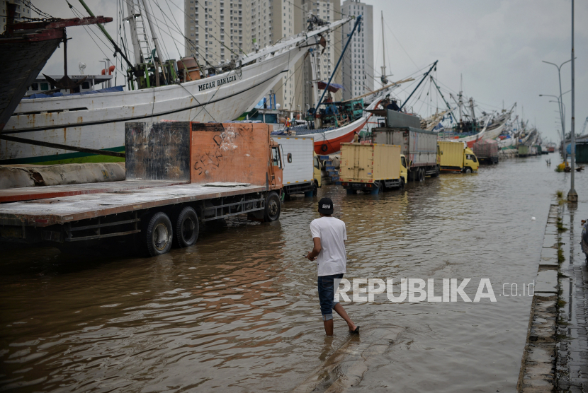 Pekerja beraktivitas saat banjir rob di Pelabuhan Sunda Kelapa, Jakarta Utara, Senin (26/12/2022). Warga diminta mewaspadai potensi banjir rob hingga Senin (6/2/2023).