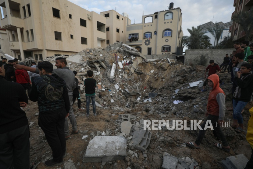 Bangunan hancur di kamp pengungsi Al Nusairat di Jalur Gaza selatan, Ahad (24/12/2023). Lebih dari 20 ribu warga Palestina dan setidaknya 1.300 warga Israel tewas. 