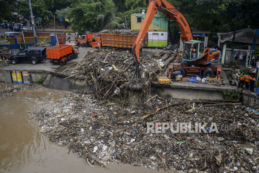 Petugas menggunakan alat berat mengangkut sampah yang terbawa aliran Sungai Ciliwung di Pintu Air Manggarai, Jakarta Pusat, Senin (10/10/2022).