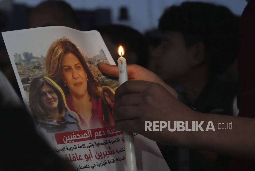 Warga Palestina memegang lilin menyala dan gambar terbunuhnya jurnalis Al Jazeera Shireen Abu Akleh, untuk mengutuk pembunuhannya, di depan kantor jaringan Al Jazeera, di Kota Gaza, Rabu, 11 Mei 2022. Masjid-Masjid di Preston Bersatu Kutuk Pembunuhan Jurnalis Aljazirah