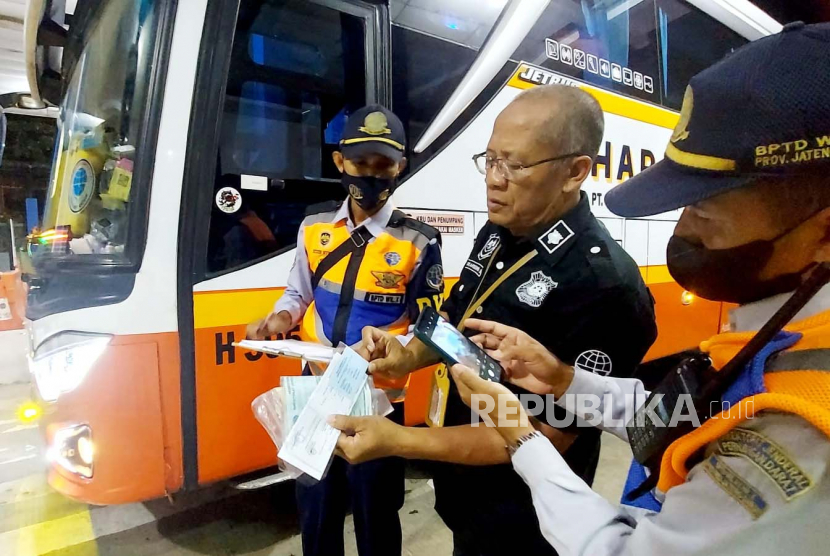 Para petugas melaksanakan kegiatan pengecekan dan  pemeriksaan kelayakan serta admistrasi bus AKAP, di Terminal Bus Antar Kota Antar Provinsi (AKAP) Tipe A Bawen, Kabupaten Semarang, Jawa Tengah, Selasa (11/4) malam. 