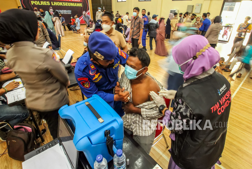 Polisi memberi semangat kepada warga saat mengikuti vaksinasi Covid-19 di Mapolres Lhokseumawe, Provinsi Aceh, Kamis (30/9/2021). 