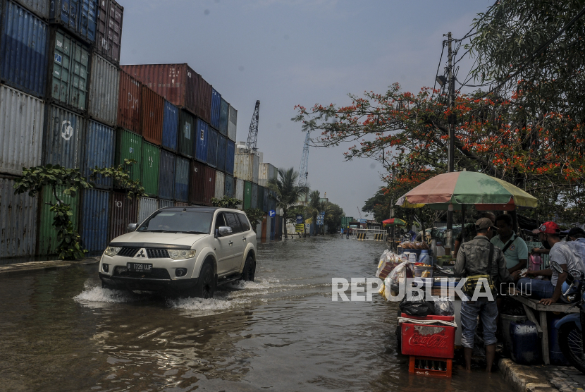 Sebuah mobil melintasi genangan air saat terjadi banjir. ilustrasi