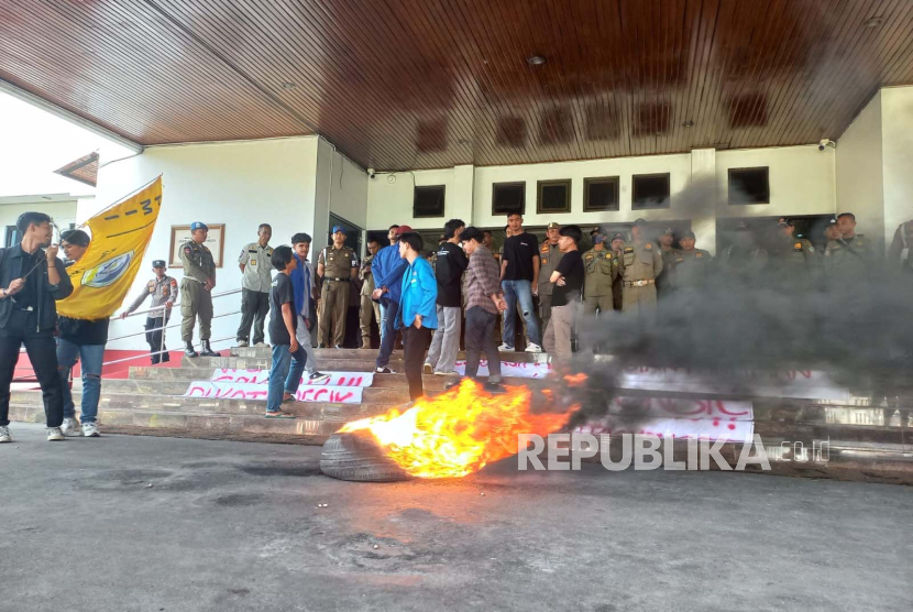 Sejumlah mahasiswa melakukan aksi bakar ban di halaman Bale Kota Tasikmalaya, Senin (20/11/2023). Mahasiswa menuntut Pemkot Tasikmalaya memperbaiki masalah pengelolaan sampah. 