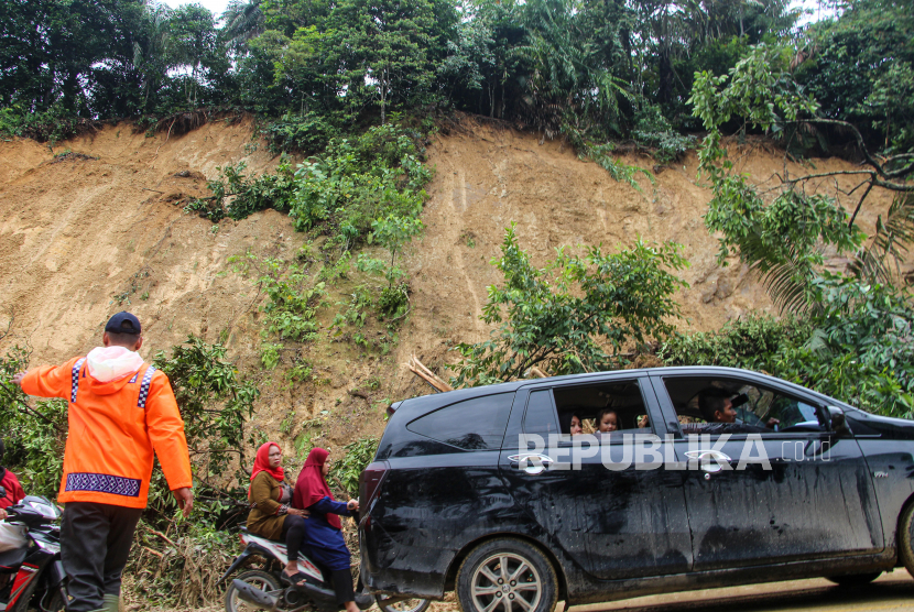 Petugas kepolisian dibantu warga mengatur lalu lintas usai longsor di Sumatra Utara. BMKG mengingatkan masyarakat mewaspadai hujan lebat di pegunungan karena bisa mengakibatkan banjir dan longsor.