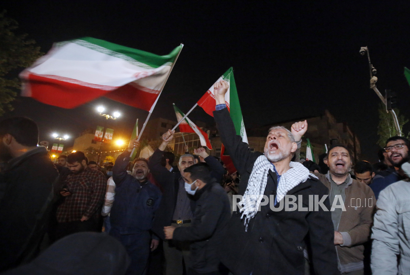 Warga Iran merayakan serangan drone Iran terhadap Israel di depan kedutaan Inggris di Teheran, Iran, Ahad (14/4/2024). 