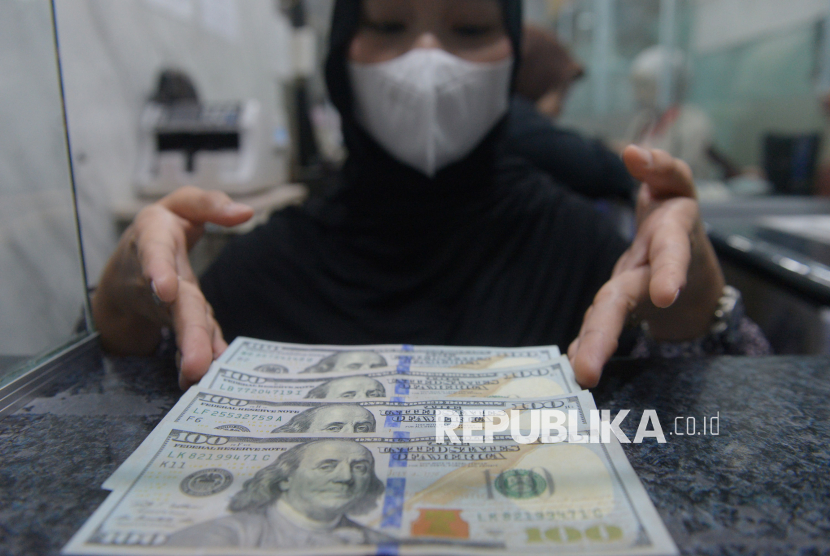 Karyawan menunjukkan uang pecahan dolar Amerika Serikat (AS) di gerai penukaran mata uang asing di Jakarta, Jumat (24/4/2026).