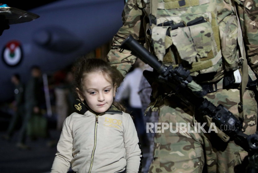 Seorang anak dari rombongan 343 warga Yordania, Palestina, Irak, Suriah, dan Jerman yang dievakuasi dari Sudan turun dari pesawat militer di Bandara Militer Marka, di Amman, Yordania.