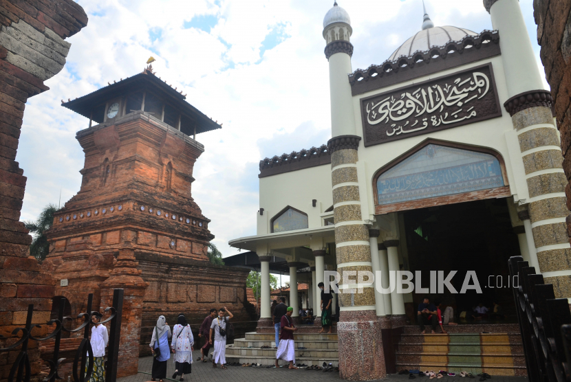 Naskah Khutbah Jumat: Merantau demi Belajar Agama. Pengunjung berjalan di depan Masjid Menara Kudus, Kudus, Jawa Tengah.