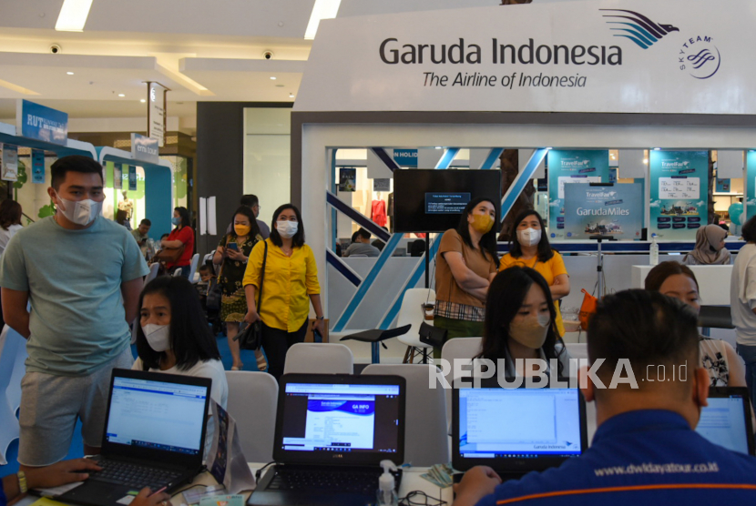 Petugas melayani pengunjung yang mencari informasi pemesanan tiket pada acara Garuda Indonesia Travel Fair (GATF) di Medan, Sumatera Utara, Jumat (4/11/2022). Gembok saham emiten maskapai PT Garuda Indonesia (Persero) Tbk resmi dibuka.
