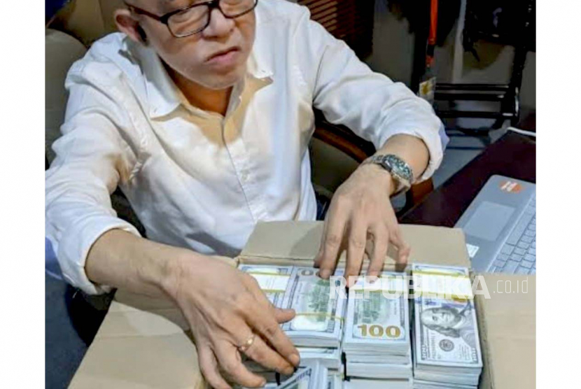 Foto diduga pria bernama Don Adam bersama uang dolar AS. Uang tersebut diduga terkait kasus korupsi BTS.