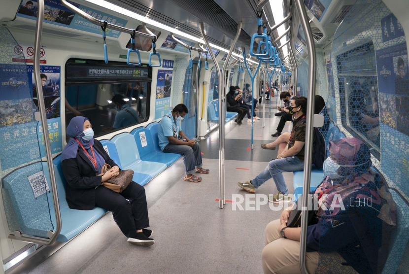 Penumpang dengan  mengenakan masker berada di kereta Mass Rapid Transit, Kuala Lumpur, Malaysia, Senin (4/5). Banyak sektor bisnis dibuka kembali pada Senin di beberapa bagian Malaysia sejak diberlakukannya lockdown pada 18 Maret lalu
