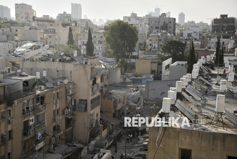 Petugas penyelamat, polisi dan militer memeriksa bangunan yang hancur terkena rudal Iran di Bnei Brak, Tel Aviv, Senin (16/6/2025). Serangan Iran membuat sejumlah bangunan di Israel hancur berantakan. Komando Front Dalam Negeri Israel mengatakan serangan Iran meluas dari Eilat di selatan hingga kota Naqoura di utara, tanpa sepenuhnya bisa dicegat sistem pertahanan udara.