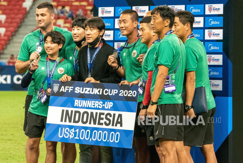 Pelatih Timnas Indonesia Shin Tae-yong (keempat kiri) dan sejumlah staf pelatih berfoto usai pengalungan medali Piala AFF 2020, di National Stadium, Singapura, Sabtu (1/1/2022). Indonesia menduduki juara kedua usai seri melawan Timnas Thailand dengan skor 2-2 atau kalah agregat 2-6.  ANTARA FOTO/Flona Hakim/app/hp.