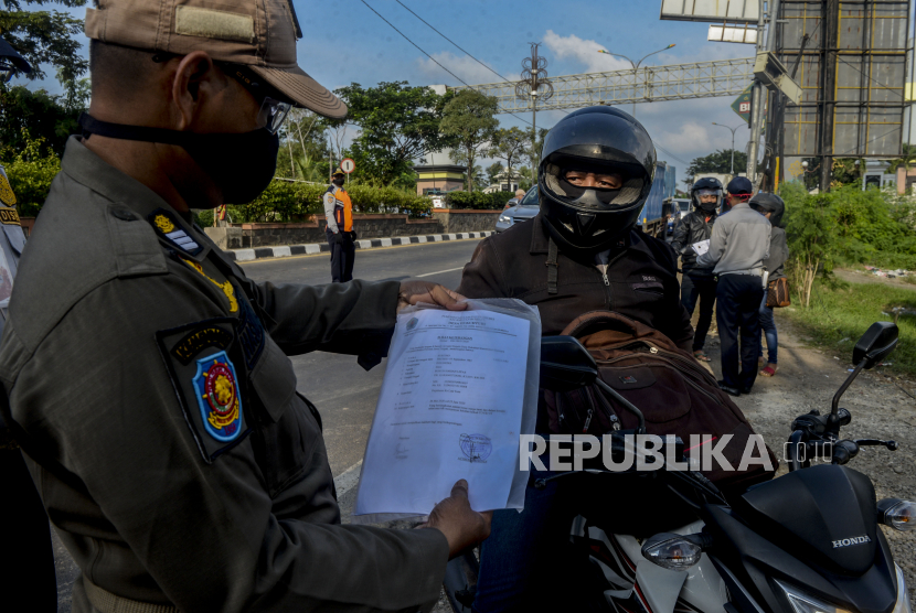 Petugas Satpol PP saat memeriksa dokumen pengendara yang akan memasuki wilayah DKI Jakarta. Ilustrasi
