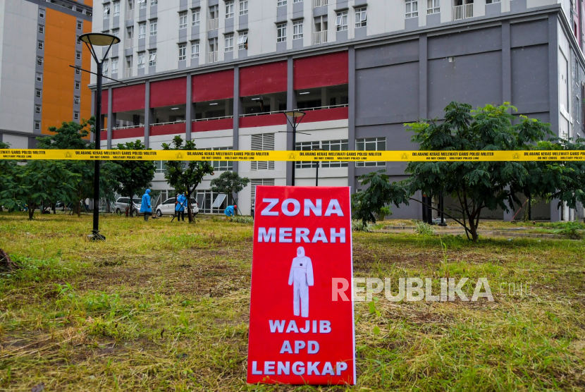 Petugas melintas di depan tower tujuh RS Darurat Covid-19, kompleks Wisma Atlet di Kemayoran, Jakarta, Ahad (22/3/2020). 