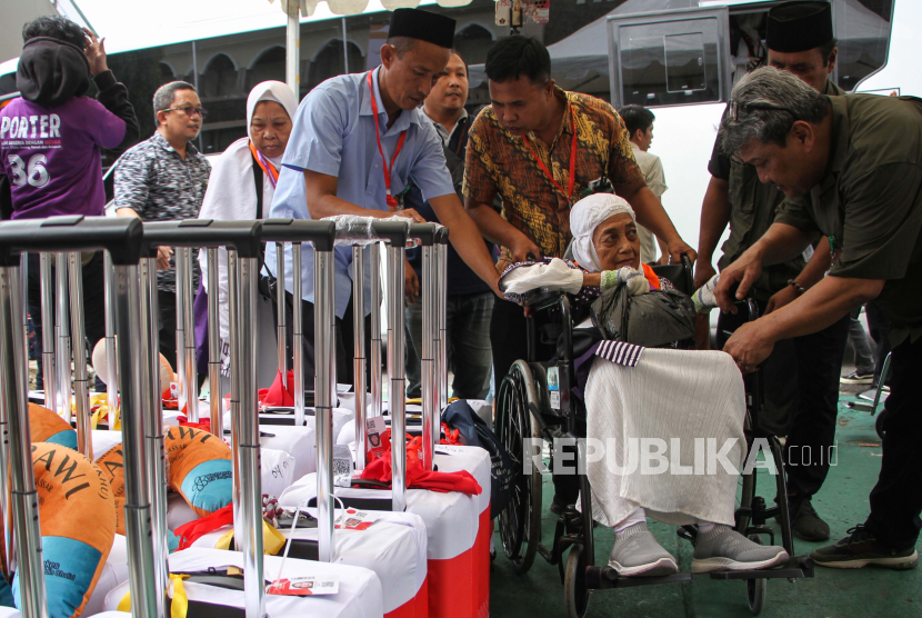 Petugas membantu Jamaah Calon Haji (JCH) kelompok terbang (kloter) pertama embarkasi Makassar yang tiba di Asrama Haji Sudiang, Makassar, Sulawesi Selatan, Sabtu (11/5/2024). 