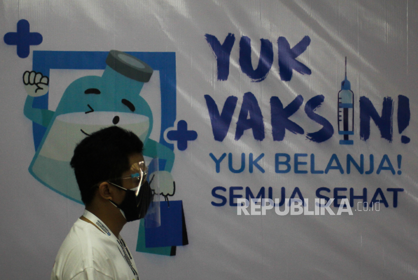 Warga berjalan di dekat spanduk ajakan vaksin di Sentra Vaksinasi di Gedung Kencana, Surabaya, Jawa Timur, Jumat (30/7/2021). Diabetesi perlu mendapatkan vaksin Covid-19 untuk mencegah komplikasi. 
