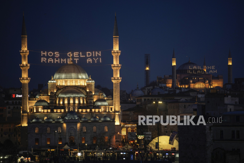 Pesan teks  di masjid Yeni, atau Masjid baru (kiri) dibaca dalam bahasa Turki Selamat datang bulan rahmat, dan di masjid Hagia Sophia Tidak ada Tuhan selain Allah menjelang bulan suci umat Islam Ramadhan, di Istanbul, Turki, Ahad (10/3/2024).