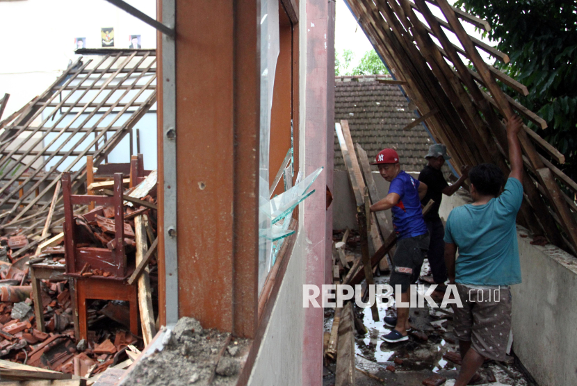 Pekerja membersihkan reruntuhan atap ruang kelas yang ambruk di SMP Islam Al Amin, Malang, Jawa Timur, Kamis (20/2/2025). Atap ruang kelas di sekolah tersebut ambruk sebab tak kuat menahan derasnya hujan dan mengakibatkan sebanyak 210 siswa dari enam kelas sementara menjalani proses belajar mengajar secara daring. 