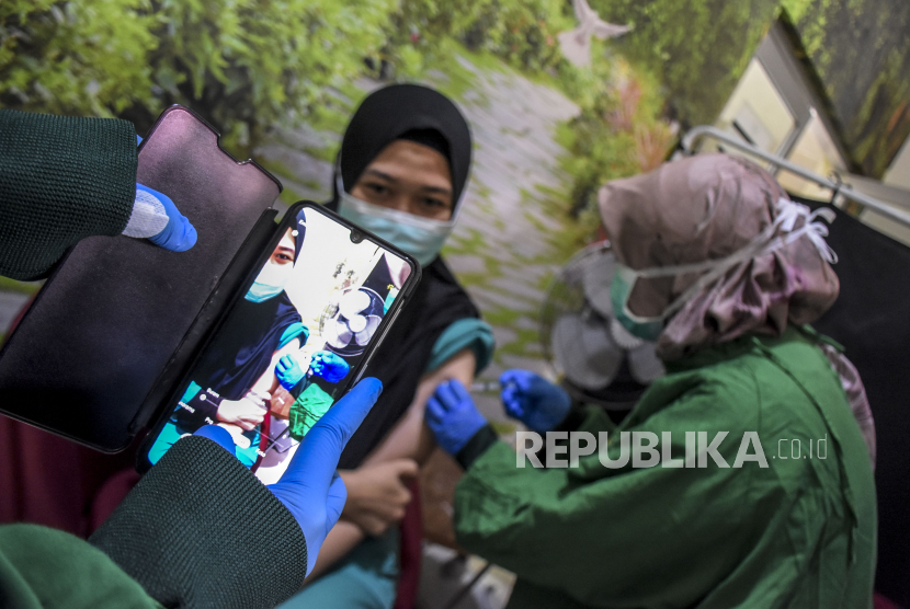 Vaksinator menyuntikkan vaksin Covid-19 dosis keempat (booster kedua) ke seorang tenaga kesehatan di Rumah Sakit Mata Cicendo, Jalan Cicendo, Sumur Bandung, Kota Bandung, Senin (1/8/2022). Vaksinasi dosis keempat tersebut menargetkan sebanyak 700 sumber daya manusia (SDM) kesehatan dengan ketersediaan 30 dosis vaksin per hari. Foto: Republika/Abdan Syakura