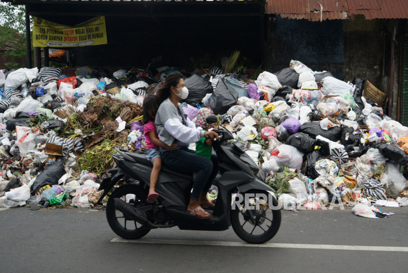 Warga melintas di dekat tumpakan sampah di kawasan Lempuyangan, Yogyakarta, Selasa (10/5/2022). Warga Yogyakarta mengeluhkan gunungan sampah di jalan akibat TPST Piyungan diblokir.