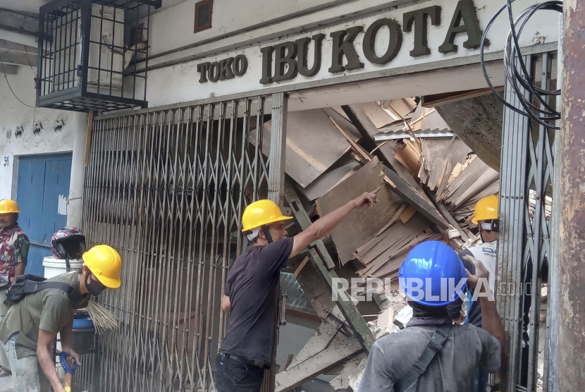  Pekerja memeriksa toko yang rusak akibat gempa bumi di Cianjur, Jawa Barat, Senin, 21 November 2022. Gempa bumi yang mengguncang pulau utama Indonesia di Jawa pada hari Senin merusak puluhan bangunan dan membuat warga mengungsi ke jalan-jalan ibu kota demi keselamatan.