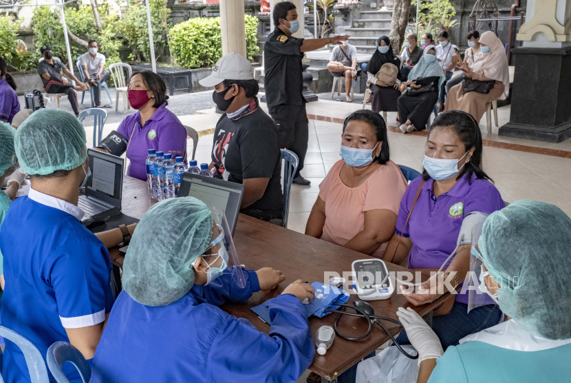 Seorang perempuan menjalani pemeriksaan kesehatan sebelum menerima suntikan vaksin COVID-19 saat kampanye vaksinasi COVID-19 massal untuk lansia di Denpasar, Bali, Indonesia, 06 April 2021. 