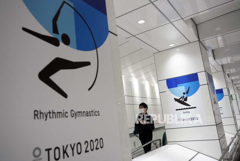 Seseorang berjalan melewati papan iklan Olimpiade Tokyo di Tokyo, Jepang, 27 Januari 2021. Komite Olimpiade Internasional akan mengadakan pertemuan Dewan Eksekutif mengenai Olimpiade Tokyo yang dijadwalkan ulang untuk dibuka pada tanggal 23 Juli 2021. 
