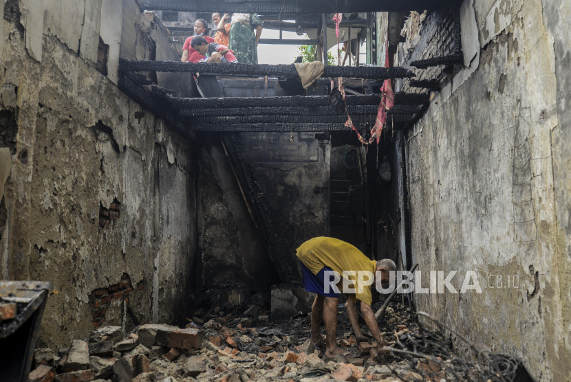 Seorang warga mencari barang berharga yang masih bisa diselamatkan pasca kebakaran di kawasan Grogol. - Sebanyak 45 kepala keluarga (KK) yang terdiri atas 200 jiwa kehilangan tempat tinggal akibat kebakaran yang menghanguskan 25 rumah di kawasan padat penduduk di Grogol, Jakarta Barat, Senin (9/8) malam. Mereka terpaksa mengungsi di sejumlah tempat. 