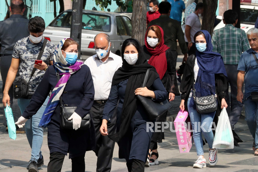 Orang Iran menghadapi topeng pergi berbelanja di sekitar pasar raya Teheran di Teheran, Iran.